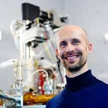 Portrait of Kimmo Mustonen in front of the Nion UltraSTEM 100 microscope.