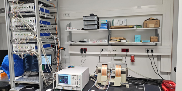 Experimental inverse-design setup consisting of the device itself, mounted between the pole shoes of an electromagnet, vector network analyzer (VNA), the five multi-channel current sources, other components and a PC for running the algorithms required to solve the inverse problem.