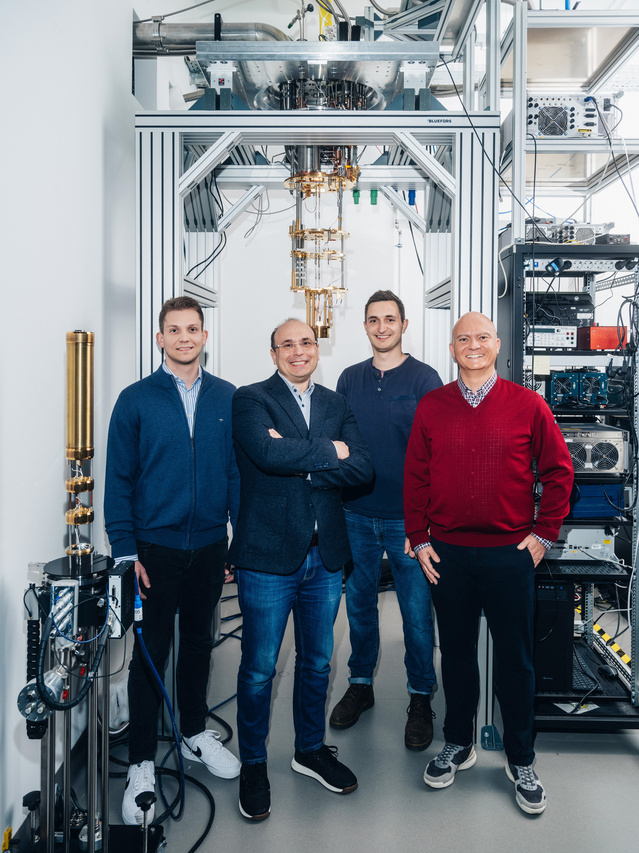 Ein Porträt vonRostyslav Serha, Andrii Chumak, David Schmoll und Sebastian Knauer vor einem Kryostaten.